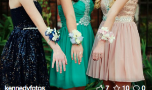 Three girls showing their corsages.