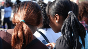 Two girls checking the phone at at event.