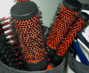 Different sized hair brushes in a basket.