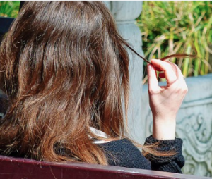 Woman twirling a piece of her hair