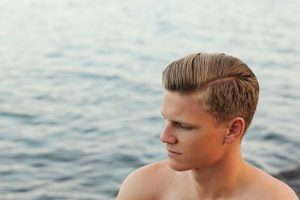 White guy with side part and pompadour.