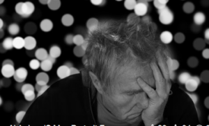 Man with head in hand looking stressed.