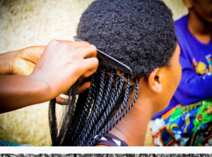 Woman having hair braided.