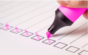 Person checking off list with pink highlighter.