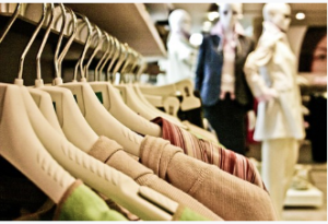 Clothes on hangers with dressed mannequins nearby.