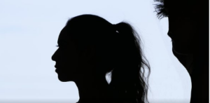 Silhouette image of a female with hair in a ponytail with a male beside her.