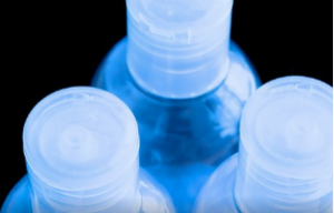 Three clear bottles arranged together in a blue shadow.