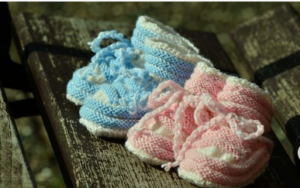 Image of blue and pink crocheted baby booties with laces.