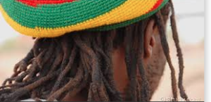 Back of Rastafarian man in tam of red, yellow and cold.