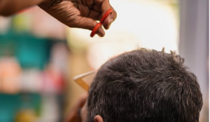Image of male getting a haircut with scissors and comb.