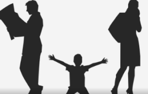 Child with hand in air trying to attract attention of preoccupied parents on either side of him.