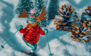 Moose in red and green snow gear skiing down a hill.