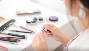 female sitting at her vanity table doing make up.