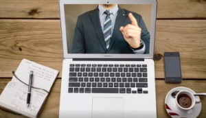 Computer with live video running with writing pad and a cup of coffee.