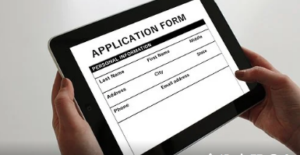 Hands holding a black ipad with online job application form on screen.