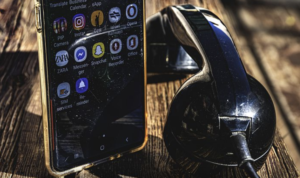 A modern cellphone and an old telephone beside each other.
