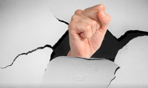 A hand punching through a board.