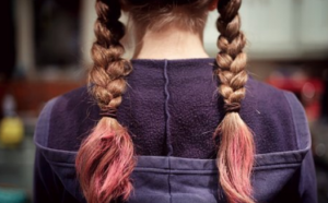 Caucasian child with hair in two french braids with pink tails.