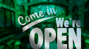 A green with white letters "come in we're open" sign.
