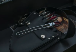 A set of hairstylist's tools in a black, leather pouch.