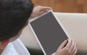 Person looking at a white tablet.