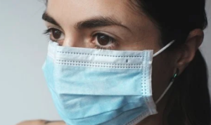 Female with a blue and white medical mask.