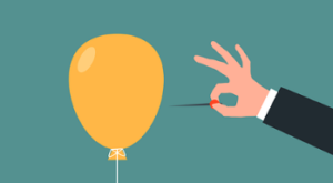 Hand in a black jacket about to pop a yellow balloon with a needle.