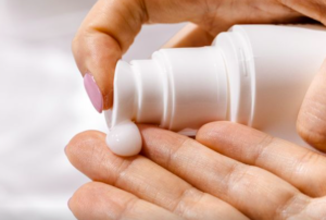 Hand squirting lotion into the other hand.