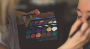 Hands of Make-up artist applying product from a make-up palette.