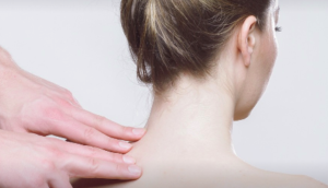Image of a professional massaging a patient's neck.