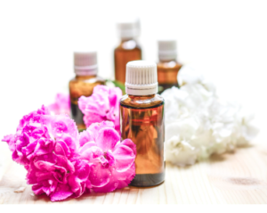 Amber dropper bottles of oil beside pink and white flowers