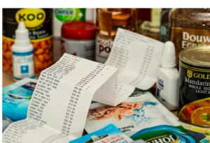 A long grocery bill surrounded by bottled goods.