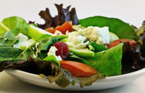 A garden salad with feta cheese and raspberries.