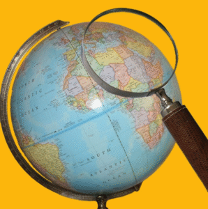 A magnifying glass over a world globe map.