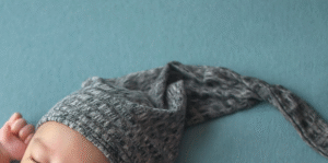 A baby sleeping with a sleep cap.