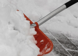 A red shovel pushing snow.