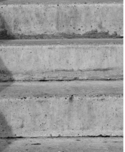 Three weathered concrete steps photographed in black and white