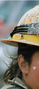 A construction worker's hat and skin filled with debris.