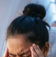 A high dark brown ponytail on a person in despair.